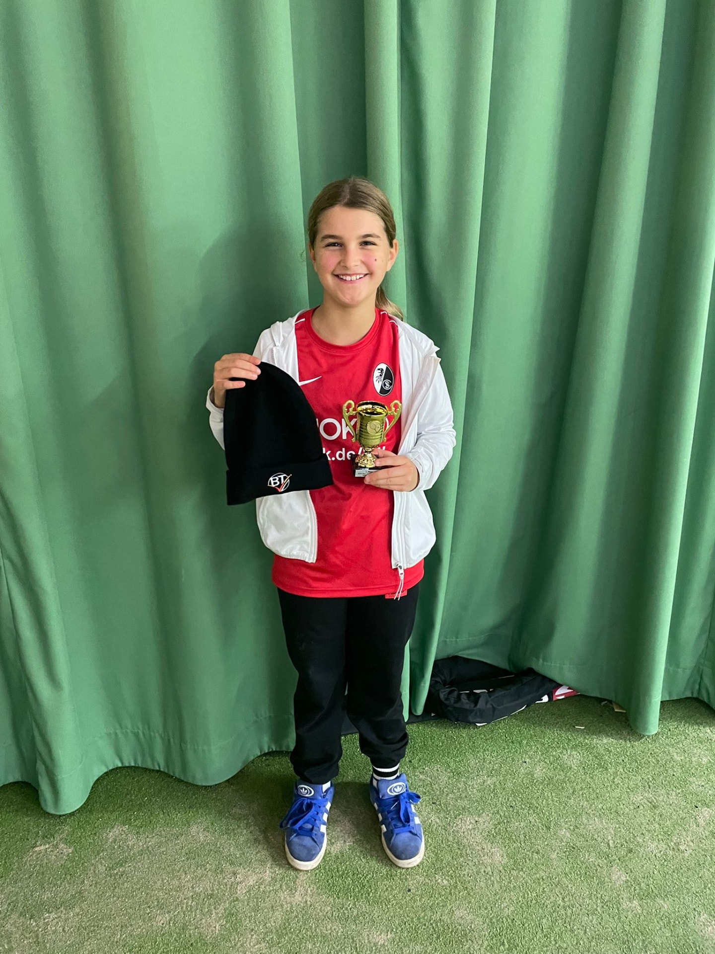 Elisa mit Pokal und Mütze – Bezirksmeisterin Juniorinnen U9